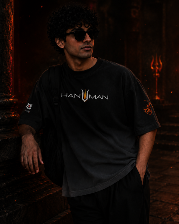 Male model leaning against a temple pillar wearing the BhaariGear Lord Hanuman black ombré t-shirt.